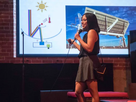 Liliana Ruiz Diaz giving an Energy Talk with a presentation projected behind her